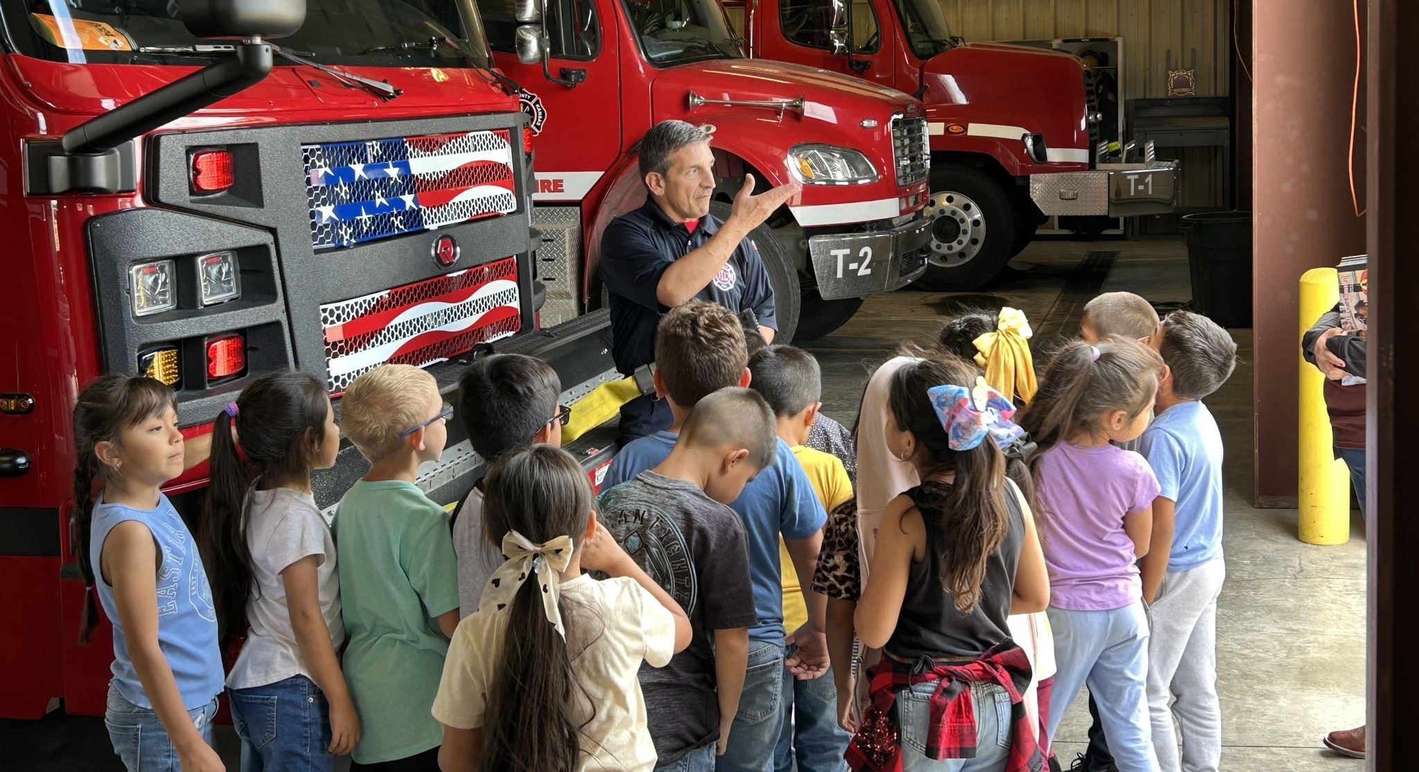 Students listen to a firefighter during a station tour.